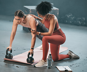 Image showing Personal trainer, stopwatch and fitness with a woman athlete lifting weights during a plank in the gym for a workout. Coach, time and exercise with a female training using kettle bell equipment