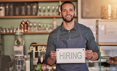 Image showing Small business, man or business owner with a hiring sign for job vacancy offer in cafe or coffee shop. Boss, marketing or happy entrepreneur smiles with an onborading recruitment message in store