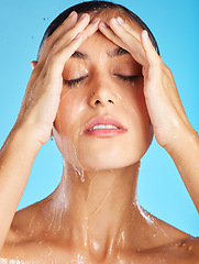 Image showing Woman, water and morning shower of a face for beauty, skincare and peace. Calm, relax and isolated young person doing wellness self care for skin glow with spa facial with blue studio background