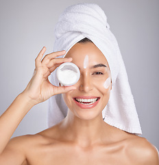 Image showing Woman, cream and skin in studio portrait for wellness, aesthetic or cosmetic health with towel by backdrop. Young healthy model, skincare lotion or beauty for facial, self care or smile for cosmetics