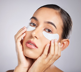 Image showing Beauty, eye patch and face of woman with skincare product for self care, anti aging or facial wellness. Healthcare, spa salon and portrait of aesthetic girl with makeup cosmetics on studio background