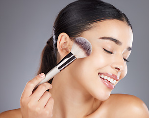 Image showing Makeup, beauty or woman with a brush for facial cosmetics or luxury skincare products. Face, aesthetic or happy beautiful girl model smiles grooming in self care routine isolated on studio background