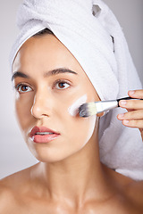 Image showing Woman, makeup and brush in studio with towel for cosmetic beauty application, natural aesthetic and wellness. Model, skin health and self care facial for healthy radiant glow on face with skincare