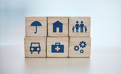 Image showing Wooden, cubes or stack in house risk management, security or future protect on background desk mockup or home table. Zoom, building blocks or life insurance in medical, car loan or mock up cog wheel