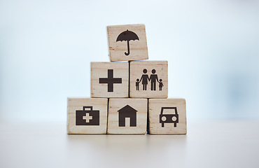 Image showing Building blocks, pyramid and life insurance for medical, car loan or home on background mockup, table or desk mock up. Zoom, wooden and cubes for house risk management, security and future protection