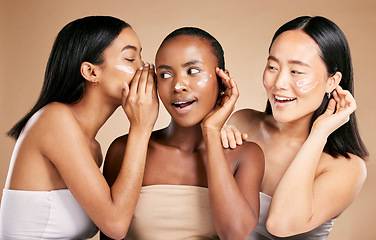 Image showing Beauty secret, skincare cream and diversity women friends whisper about inclusion advertising in studio. Asian and black people talk about wow skin glow, spa facial and face with dermatology product