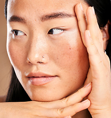 Image showing Closeup face, hand frame and asian woman in studio with skincare, skin glow or healthy cosmetics. Happy japanese model, cosmetic beauty and aesthetic with self care health, wellness or natural makeup