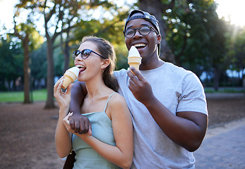 Image showing Love, ice cream or couple of friends in a park walking on a romantic date in nature in an interracial relationship. Romance, black man and happy woman eating or enjoying a snack on a holiday vacation