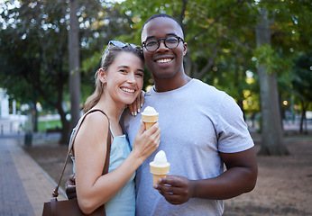 Image showing Eating, interracial and portrait of couple with ice cream in a park on a date, anniversary or walk. Love, smile and man and woman with a sweet dessert while walking in nature with romantic affection