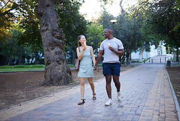 Image showing Couple on date in park, ice cream and holding hands outdoor, love and commitment in relationship. Romance in nature, black man and woman eat dessert for quality time together, trust and interracial