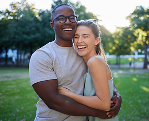 Image showing Love, interracial or couple of friends hug in a park on a happy romantic date bonding in nature together. Romance, funny black man and woman laughing or enjoying quality time on a holiday vacation