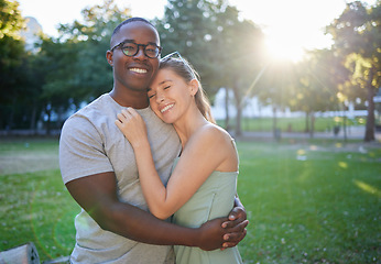 Image showing Love, hug or couple of friends in a park on a relaxing romantic date in nature in an interracial relationship. Bonding, black man and happy woman enjoying quality time on a holiday vacation together