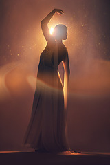 Image showing Fantasy, orange lighting and silhouette of woman on stage for creative fashion, art deco and beauty. Ballet dancer, aesthetic and shadow of girl pose for dream, magic and freedom in glowing studio