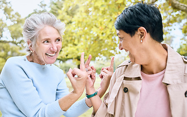 Image showing Elderly, women and middle finger at the park for fun, humor and silly while laughing together. Mature, friends and females with hand, emoji and gesture, playful and happy, smile and bonding in nature