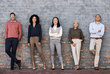 Image showing Portrait, collaboration and goals with a business team standing together, leaning on a brick wall. Teamwork, mindset and vision with a man and woman employee group outside for future success