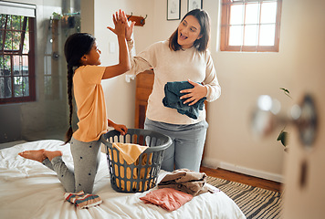 Image showing Cleaning, high five and child and mother doing laundry clothes, house work and fold clean fabric. Love bond, home bedroom or happy family kid with basket container and celebrate domestic housekeeping