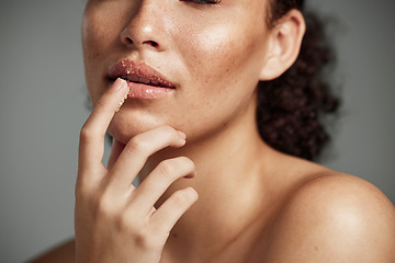 Image showing Woman, hand and lips in sugar scrub for skincare, makeup or cosmetics against a grey studio background. Happy female applying treatment for facial cosmetic, lip dermatology or mouth exfoliation