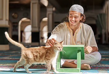 Image showing Muslim, man and cat in a mosque, happy and smile during, worship, prayer and bonding. Islamic, male and animal in holy, religious place for praying, humble and sitting for pray and learning