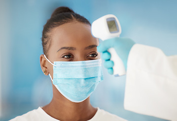 Image showing Temperature, healthcare and black woman with covid test for medical safety, consultation and health. Thermometer, sick and African girl with a face mask for a virus and hand of a doctor to check