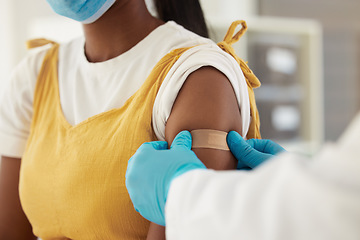 Image showing Vaccine, covid and a plaster on the arm of a black woman in a hospital for healthcare. Nurse, doctor and medical with a medicine professional in a clinic to apply a bandaid after corona vaccination