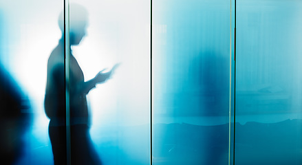 Image showing Glass wall, email and businessman reading on a phone for contact, communication and work. Silhouette, social media and employee typing on a mobile chat with news, information and app for work