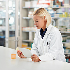 Image showing Woman pharmacist in pharmacy, tablet and pill bottle for medical research and check side effects of medicine. Technology, internet with online info on pharmaceutical drugs and health professional