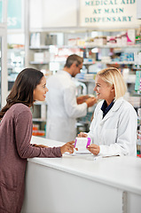 Image showing Wellness, health and happy pharmacy customer at store counter for medicine expertise with smile. Pharmaceutical advice and opinion of woman pharmacist helping girl with medication information.