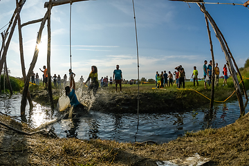 Image showing Athletes go through mud and water