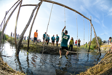 Image showing Athletes go through mud and water