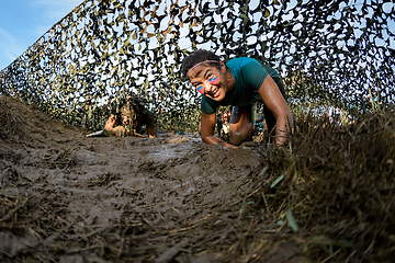 Image showing Athletes crawling through mud