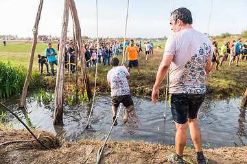 Image showing Athletes go through mud and water