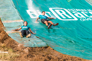 Image showing Athletes sliding to mud and water