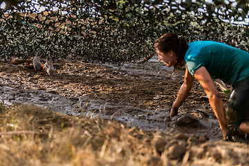 Image showing Athletes crawling through mud