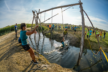 Image showing Athletes go through mud and water