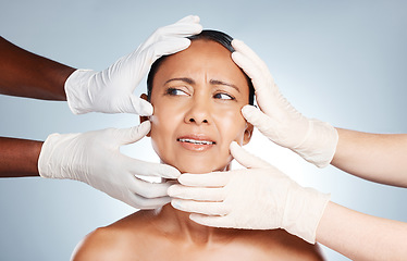 Image showing Plastic surgery, confused and face of woman with hands from doctors isolated on blue background. Skincare, check and senior person worried about botox, cosmetic and facial surgery with professionals