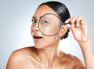 Image showing Magnifying glass, skincare and mature woman in a studio with a health, wellness and natural face routine. Beauty, cosmetic and portrait of a female with a lens for an anti aging facial treatment.