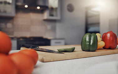 Image showing Kitchen, table and cutting board with vegetables of colorful peppers for healthy meal preparation at home. Food, cooking or nutrition of organic grown consumables on counter for diet plan or vitamins