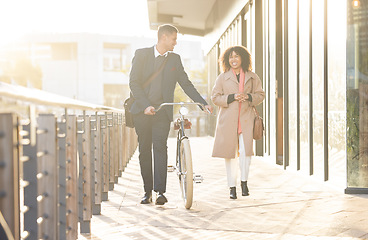 Image showing Business couple, bicycle and walking outdoor in urban city for freedom, relax conversation and travel commute. Businessman, woman smile and happy speaking together on bike walk for carbon footprint