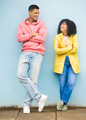 Image showing Happy couple, smile and cool fashion standing in urban town wall background for conversation, peace and relax together. Casual man, trendy woman and happiness speaking for millennial street style