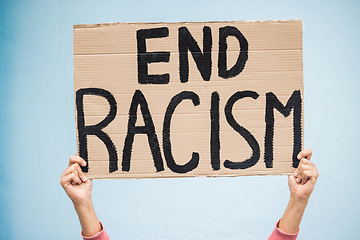 Image showing Hands, cardboard poster and end racism for protest, march or community advertisement against studio background. Hand of activist holding billboard, banner or sign for equality, message or protesting