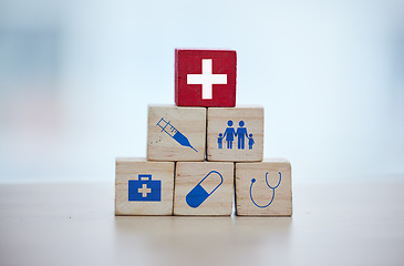 Image showing Health, insurance and wooden blocks in studio on an empty gray background for safety or security. Abstract, medicine and healthcare with block toys in a hospital or clinic for medical care