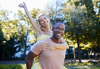 Image showing Interracial couple, piggy back and portrait of people with love, care and smile on summer park date. Happiness, hug and young man and woman outdoor on adventure together happy with bonding in nature