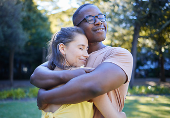 Image showing Black man, interracial couple and hug on park lawn with love, care and bonding for quality time, reunion and happiness. Multicultural embrace, happy relationship and outdoor diversity on adventure