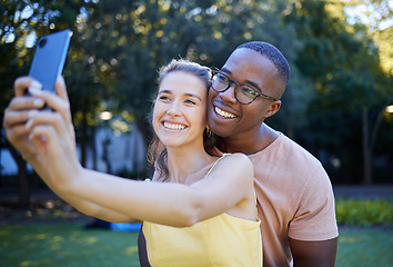 Image showing Selfie, phone and interracial couple smile in park enjoying weekend, summer holiday and quality time together. Nature, dating and happy man and woman relax, calm and hug to take picture on smartphone