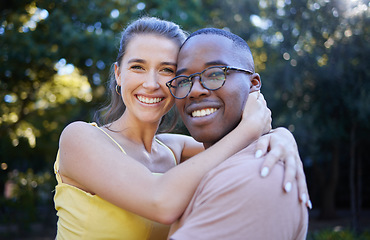 Image showing Portrait, couple on a date and hug with love in nature, outdoor in park with commitment in interracial relationship. Trust, support and happy people, black man and woman smile on face with fresh air