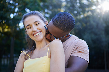 Image showing Love, park and kissing with an interracial couple bonding outdoor together on a romantic date in nature. Summer, romance and diversity with a man and woman dating outside in a green garden