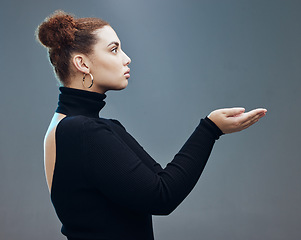 Image showing Hand, woman and holding gesture in studio with mockup, space and grey background for product placement. Young, beautiful and girl with open palm hands on mock up, branding and showing copy space