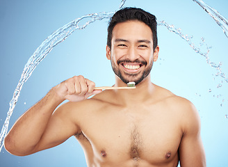Image showing Water splash, portrait or man brushing teeth in studio with toothbrush for white teeth or dental healthcare. Face, bamboo wood or happy person cleaning or washing mouth with a healthy natural smile