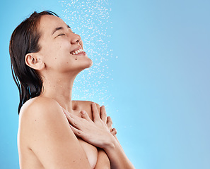 Image showing Woman, happy and shower, water and cleaning body for hygiene against blue studio mockup background. Asian female, model and shortless while showering, happiness and clean with smile and bathroom