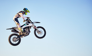 Image showing Motorcycle, jump and person on blue sky mockup for training, competition or challenge with safety gear. Professional cycling, motorbike and adventure with speed, sports and danger in mock up space